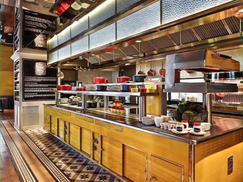 uma cozinha de restaurante com uma grande cozinha com muita comida em Sofitel Saigon Plaza em Cidade de Ho Chi Minh