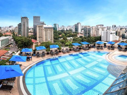 uma vista aérea de uma grande piscina com uma cidade ao fundo em Sofitel Saigon Plaza em Cidade de Ho Chi Minh