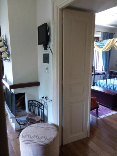 a room with a door and a living room with a fireplace at Archontiko Pantou in Portariá
