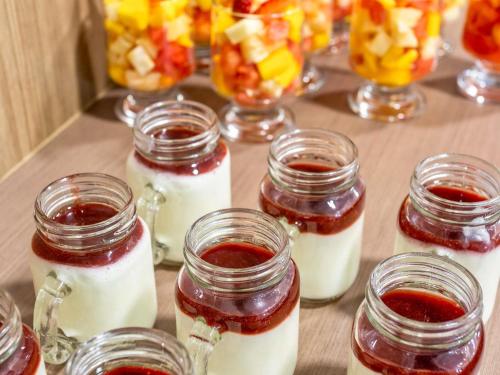 Una mesa cubierta con frascos de mermelada y crema batida en Mercure Sao Paulo JK, en São Paulo