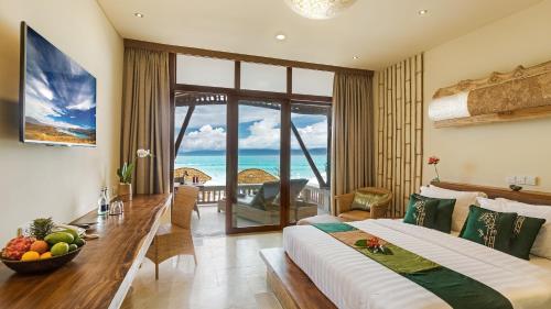 a bedroom with a bed and a view of the ocean at Pearl of Trawangan in Gili Trawangan