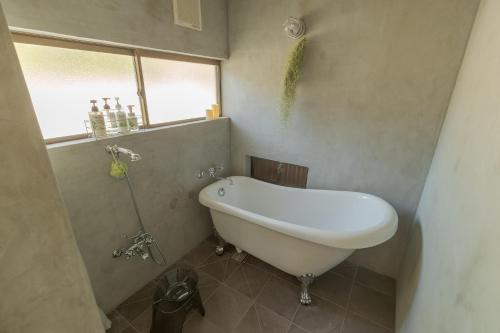 a white bath tub in a bathroom with a window at La toile in Mitoyo