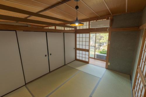 an empty room with white cabinets and a window at La toile in Mitoyo