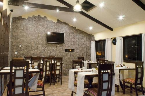 a restaurant with tables and chairs and a tv on a wall at Cusco Bed and Breakfast in Cusco