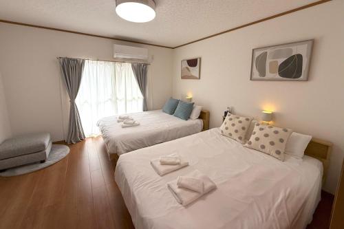 a bedroom with two beds and a window at Shinkoiwa 3BR house in Tokyo