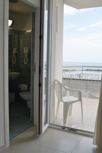 a bathroom with a chair and a view of the ocean at Hotel Tibidabo in Bellaria-Igea Marina