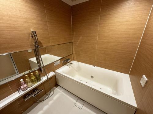 a bathroom with a white tub and a sink at Hotel La'i ローレル Adult only in Tokyo