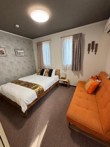 a bedroom with two beds and a couch at Yasuragi-KAWAGOE 2F in Kawagoe