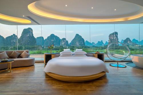 a bedroom with a bed and a large window at 桂林阳朔良宿 LS Hotel Liangsu Yangshuo in Gaotian