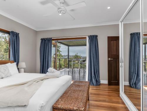 Caddys IslandにあるHillcrest Retreat with River Viewsのベッドルーム1室(ベッド1台付)、バルコニー(テーブル付)