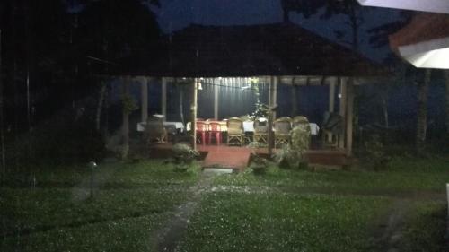 a house with a table and chairs in the rain at Lovedale Lakeside Homestay in Alleppey