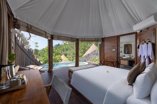 a bedroom with a bed and a table and a tub at The Wapa Lux Tent in Sidemen