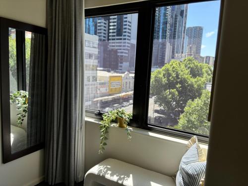 a room with a window with a view of a city at Elegant CBD Haven with City Views in Melbourne