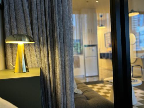 a lamp sitting on a table next to a curtain at Elegant CBD Haven with City Views in Melbourne
