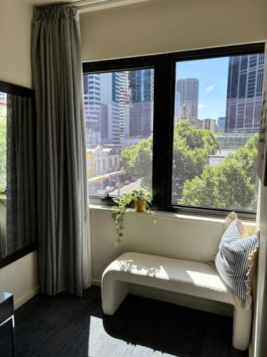 a room with a bench in front of a window at Elegant CBD Haven with City Views in Melbourne