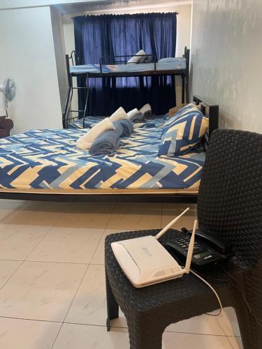 a bedroom with a bed with a laptop on a chair at Harmony Transient in Baguio