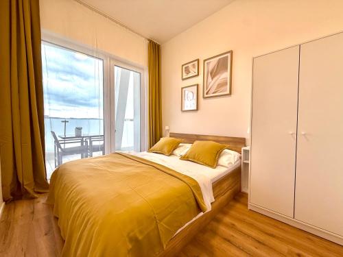 ein Schlafzimmer mit einem Bett und einem großen Fenster in der Unterkunft apartino - Moderní apartmán v novostavbě - Omezený přístup a stavební ruch do listopadu 2025 - New Building - Limited Access and Construction noise till November 2025 in Komárov