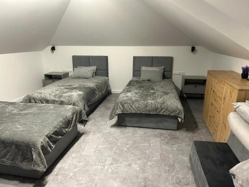 two beds in a room with two beds sidx sidx sidx at Domek pod lasem in Bolmin