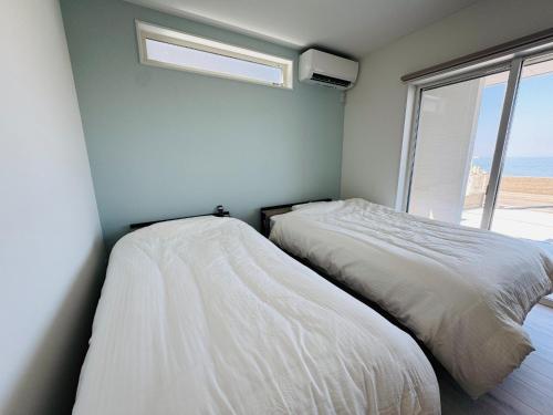 two beds in a room with a window at Villa Blanche - Vacation STAY 31400v in Sumoto