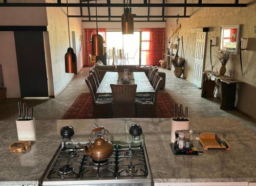 a kitchen with a stove and a table with a tea kettle at Big Cats Namibia Farmstay & Tours in Outjo