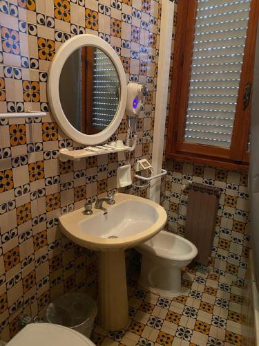 Un baño con lavabo, inodoro y espejo. en New Hotel Attico, en Chianciano Terme