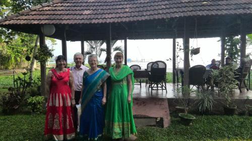 a group of people posing for a picture under a gazebo at Lovedale Lakeside Homestay in Alleppey