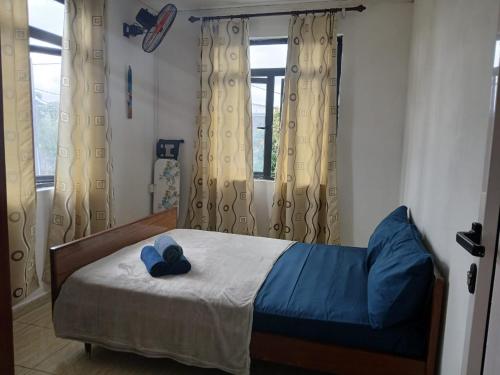 a bedroom with a bed with a blue pillow on it at Gris Gris Guest House in Souillac