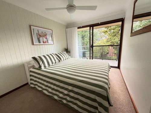 een slaapkamer met een bed en een groot raam bij Catalina Cove-From Door to Shore in 2 Minutes in Shoal Bay