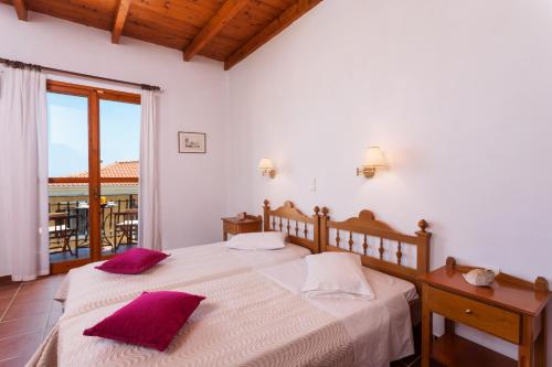a bedroom with two beds with purple pillows at Archontiko Maisonettes in Alykes