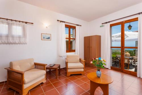 a living room with two chairs and a table at Archontiko Maisonettes in Alykes