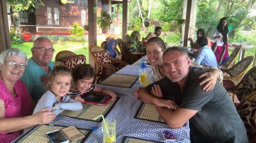 a group of people sitting at a table at Lovedale Lakeside Homestay in Alleppey