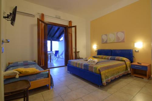 a bedroom with two beds and a sliding glass door at B&B Alighieri 21 in San Vito lo Capo