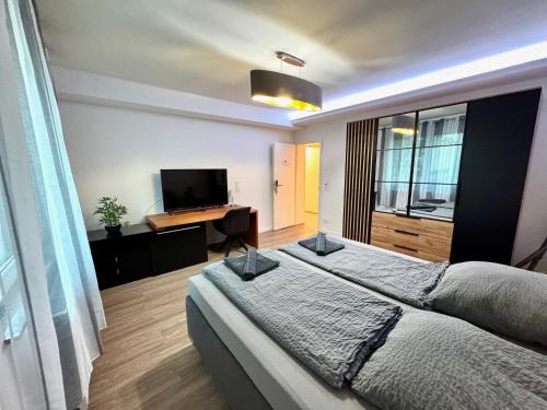 a bedroom with a large bed and a television at Porschenahe Wohung in Stuttgart