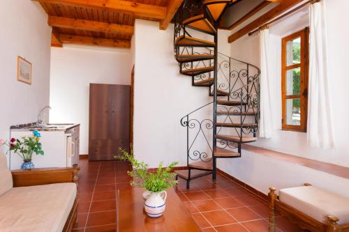 a living room with a spiral staircase in a house at Archontiko Maisonettes in Alykes