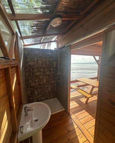 a bathroom with a sink and a view of the ocean at Fare Vai Uteute in Uturoa