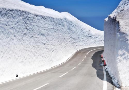 a road with snow on the side of a mountain at Zao Liza Woody Lodge in Kaminoyama