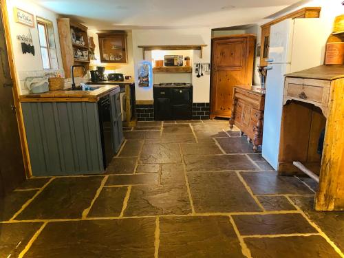 a large kitchen with a stone floor in a room at Alfie Acres - Secluded Cabin set in 5 Acres of Privacy, with Exclusive use of Swimming Pool and Hot Tub for up to 10 Guests in Downham