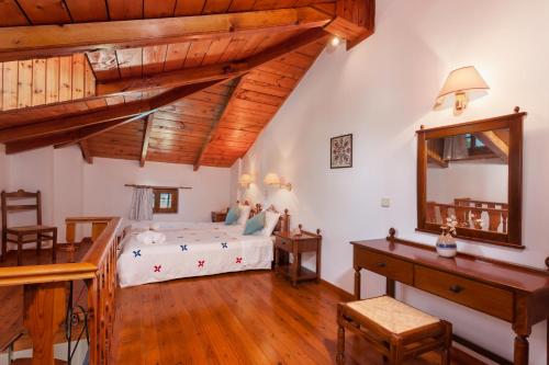 a bedroom with a bed and a desk and a mirror at Archontiko Maisonettes in Alykes