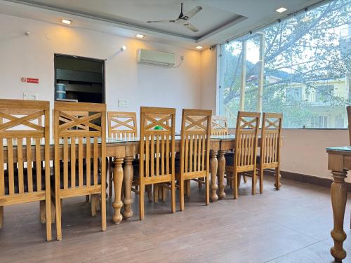 a dining room with a wooden table and chairs at WooibHotels Yogasthali Tapovan in Rishīkesh