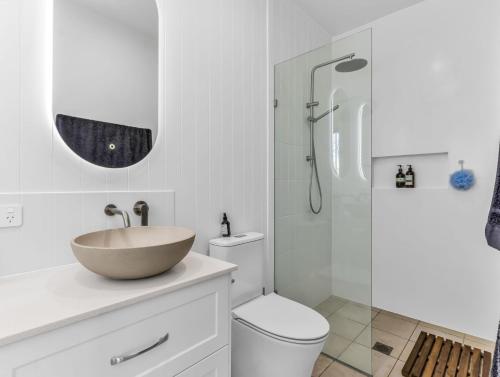 Un baño con lavabo, inodoro y ducha. en High Tide 4BR 3 level house Ocean views & Pool, en Kingscliff