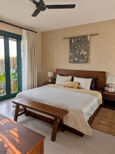 a bedroom with a large bed and a table at LAWA Bintan Berakit Village Cottage in Berakit
