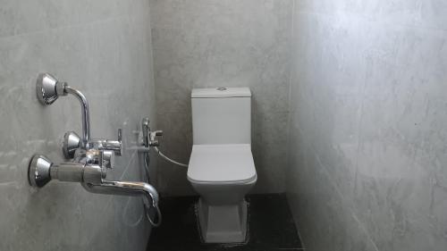 a bathroom with a white toilet in a stall at Sayatri stay in Karsiyang