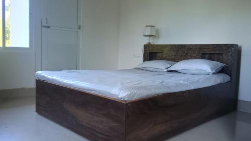 a large bed with a wooden headboard in a bedroom at Sayatri stay in Karsiyang