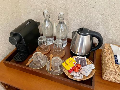 a table with a coffee maker and bottles and glasses at LAWA Bintan Berakit Village Cottage in Berakit