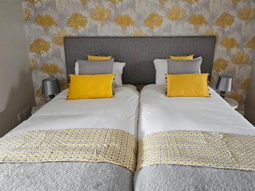 two beds with yellow pillows sitting next to each other at Brogans Apartment in Trim