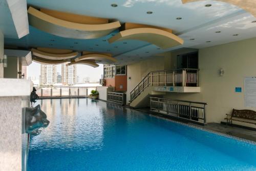 a large swimming pool with blue water in a building at LivStudios Manila Bay in Manila