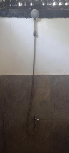 a shower with a hose attached to a wall at Dumaguete Divers in Dauin