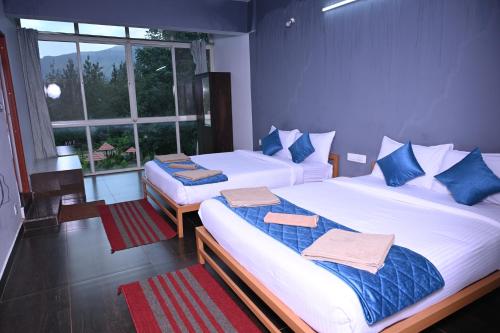 a bedroom with two beds and a window at The Nature's Nest in Attigundi