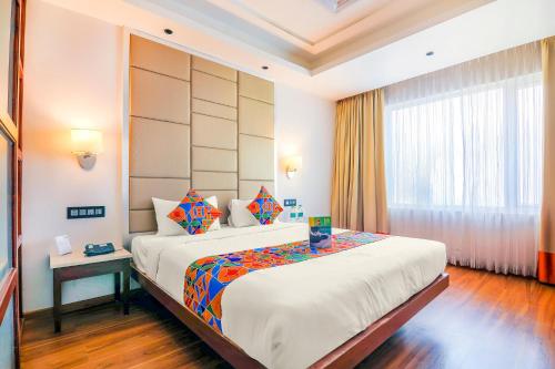 a bedroom with a large bed and a window at FabHotel High Rise Suites - Nr Marathahalli Bridge in Bengaluru