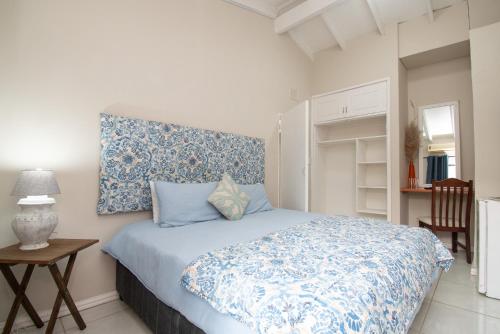 ダーバンにあるNo 20 On the Beach Guesthouseのベッドルーム1室(青と白の掛け布団付きのベッド1台付)